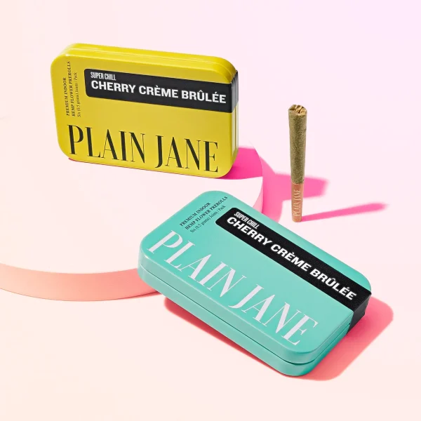 plain-jane-cherry-creme-brulee-6-pack-joints-turquoise-yellow-tins-group-shot-on-white-background-with-one-joint-on-the-outside___00904.1705087521 Plain Jane Indoor Pre-rolled Joint Pack (Six)